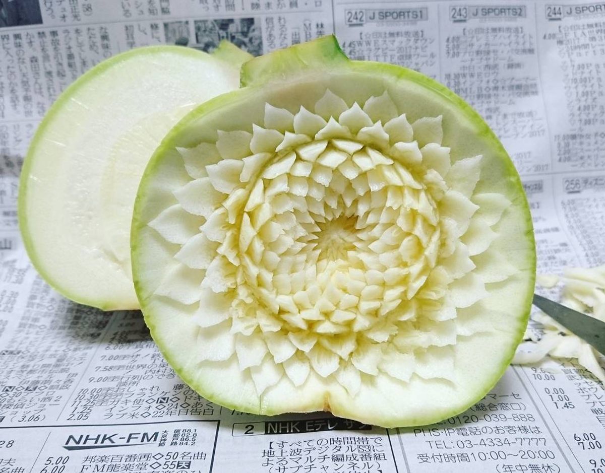 A round zucchini, carved with a peony pattern.